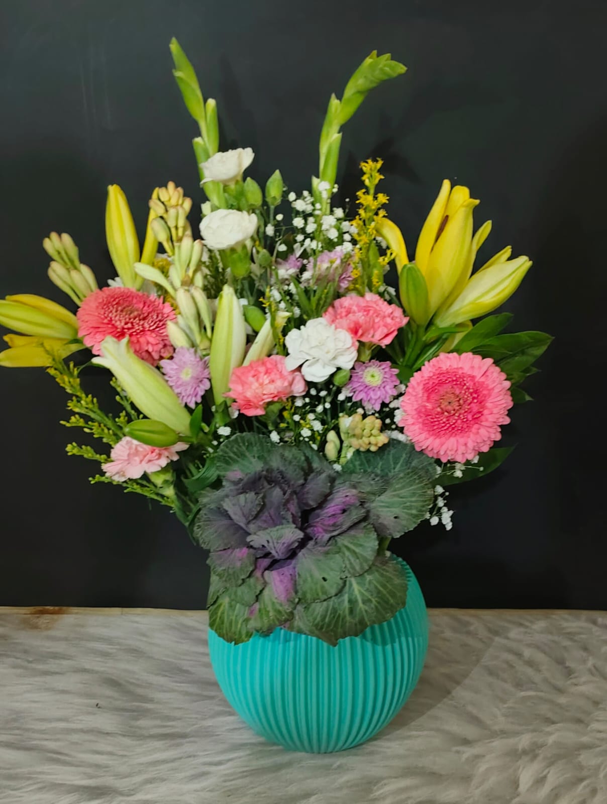 Close-up of vibrant exotic flowers including orchids, lilies, and Eustoma in a decorative vase