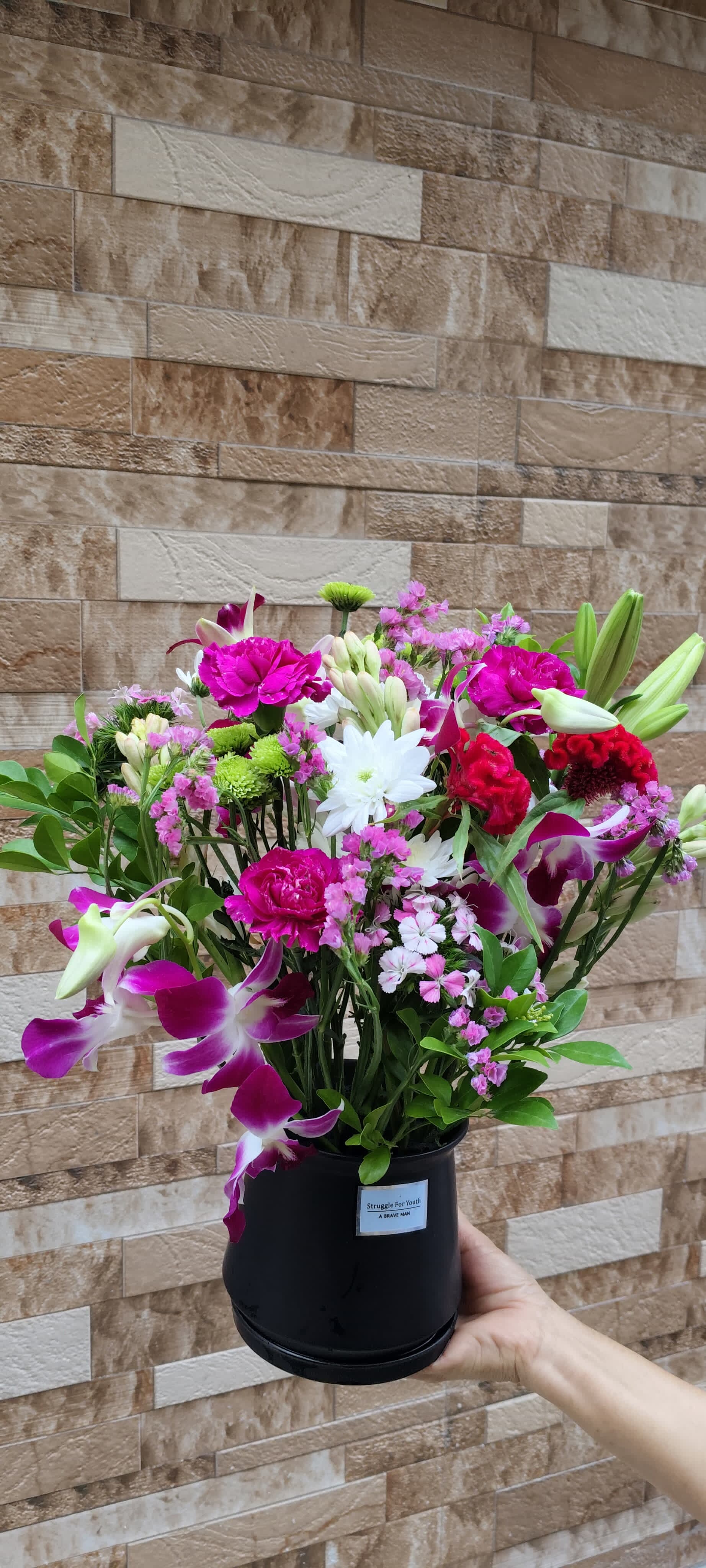 Close-up of cheerful seasonal flowers like roses, marigolds, and chrysanthemums in a simple glass vase, part of the Everyday Bloom subscription from Buds and Blooms